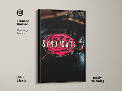 Black framed canvas of Syndicate vinyl record artwork. A red rose design on a vinyl record with gold typography. Floating frame is ready to hang. This music themed wall art is great for home decor.