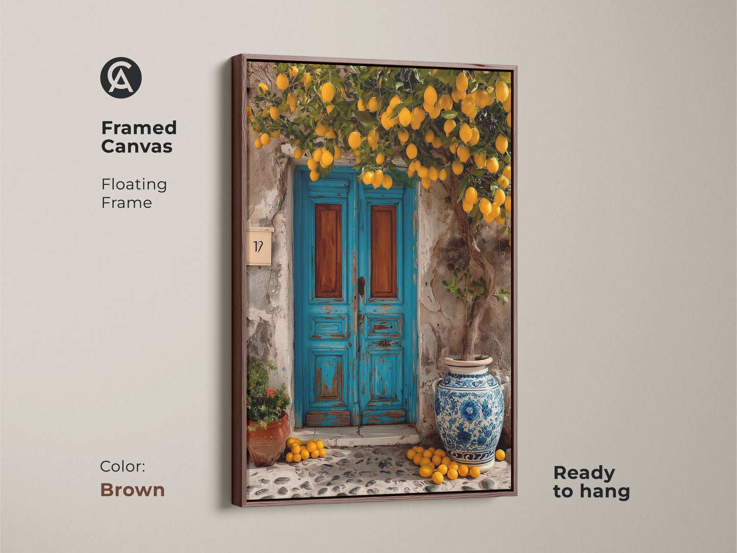 Framed canvas artwork featuring a lemon tree and a rustic blue door. Ready to hang with a brown floating frame. This Mediterranean print brings boho charm to your home decor. It is ideal as kitchen art or a thoughtful housewarming gift.