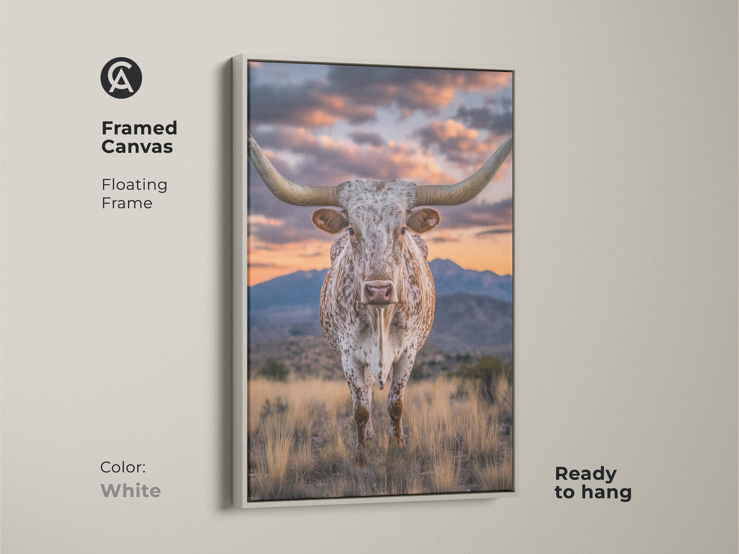 Framed canvas of a longhorn steer with a white floating frame. This rustic western artwork showcases a mountain sunset. The farmhouse landscape art is ready to hang. It's a perfect cowboy gift.