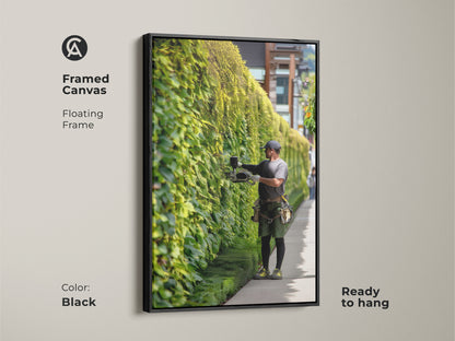 Framed canvas art showcasing a gardener trimming an ivy wall. The floating black frame enhances this ready to hang contemporary piece. A refined addition to any residential entryway decor.
