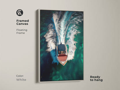 Framed canvas print of an aerial speedboat with a white floating frame. The emerald green ocean wall art captures turquoise waters. Ready to hang this contemporary boat artwork adds a modern seascape canvas.