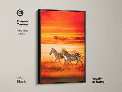 Framed canvas art features running zebras. The floating frame adds a modern touch. African savanna sunset is captured in warm tones. This wildlife scenic print is ready to hang in black.