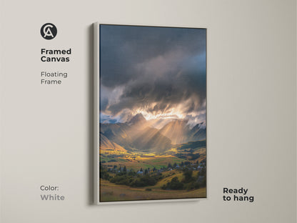 Framed canvas of a mountain valley art print. Golden hour landscape with dramatic sun rays. Floating frame in white provides a clean contemporary look. Serene landscape print for any room.