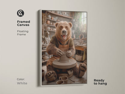 A framed canvas displays a bear at a pottery wheel. The floating frame in white complements the whimsical animal studio wall art. It's ready to hang. The earth tone bear artwork suits any room. This brown pottery scene canvas makes a unique gift for pottery lovers.