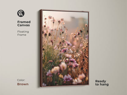 Framed canvas with a floating brown frame displaying wildflower artwork. This dreamy impressionistic canvas is ready to hang. The soft peach art print brings nature indoors. A perfect piece of botanical bedroom decor.