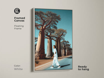 Realistic Baobab tree artwork inside a white floating frame. A woman walks a lonely road. This African landscape canvas art is ready to hang. It brings boho travel decor to any room. The white and blue tones create vacation vibes. This artwork is a unique gift idea.