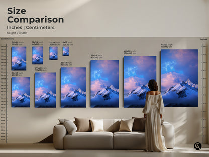 Size comparison of snowy mountain artwork in inches and centimeters. See the different sizes next to a sofa and a person. This blue and white art is great for any room. Find the perfect fit for your space today.