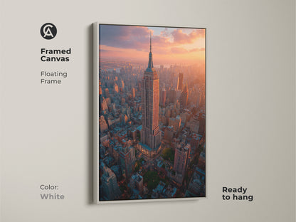 A white framed canvas print displays the Empire State Building in an aerial golden hour view. Ready to hang this New York Cityscape art enhances modern decor. Perfect for bringing a contemporary and vibrant urban photography to any space