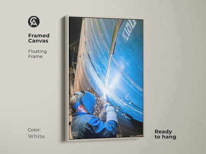 Metal fabrication art in a white floating frame. This industrial canvas art is ready to hang. The art captures the intense action of industrial welding. It is a thoughtful gift for tradespeople.