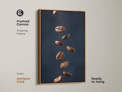 Framed canvas with floating frame featuring abstract coffee art. This minimalist kitchen wall art showcases falling coffee beans. It's a modern Tan and Dark Blue art print. The contemporary coffee decor is ready to hang adding style to any room. The frame is antique gold.