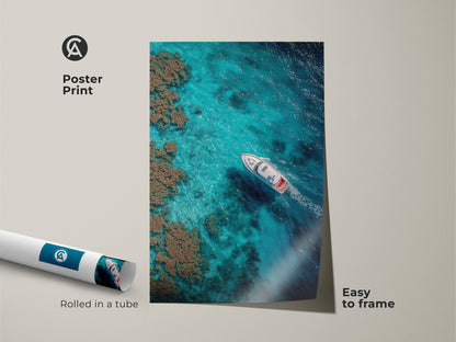 Poster print featuring aerial photography of a boat sailing. The boat is sailing on crystal-clear turquoise waters. The rolled art print is easy to frame. Perfect for coastal-themed wall decor.