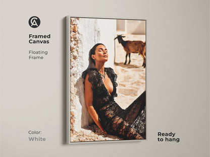 Framed Canvas with a floating white frame. The fashion photography artwork features a woman in a black lace dress with a goat. Ready to hang. Brings an eclectic touch to interiors. The artwork enhances any space. Ideal housewarming gift for fashion lovers. It's great for contemporary decor.