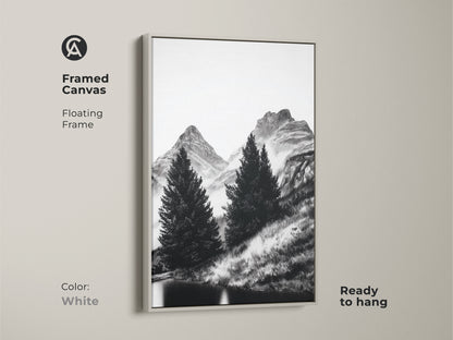 Framed canvas showcasing minimalist mountain art with a white floating frame. This black and white nature artwork captures pine trees and mountains. Ready to hang this serene landscape print will bring a peaceful scenery to any minimalist bedroom or office.