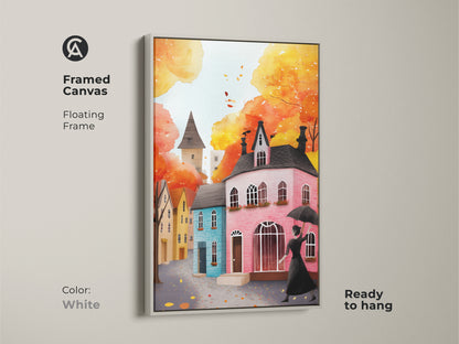 Framed canvas art print of an autumn cityscape with a white floating frame. The artwork shows a woman with an umbrella and charming houses in watercolor. Ready to hang this art piece is perfect for adding a cozy fall touch to any room. The eclectic style and warm colors create a welcoming atmosphere.