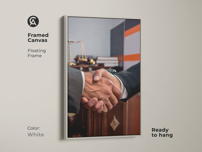 Framed canvas featuring handshake artwork perfect for a lawyer gift. Floating in a white frame it showcases scales of justice. Ready to hang this contemporary office art symbolizes a business agreement. Ideal for legal offices this dark brown and grey art promotes partnership and trust. Elevate your professional space with this sophisticated office decor.