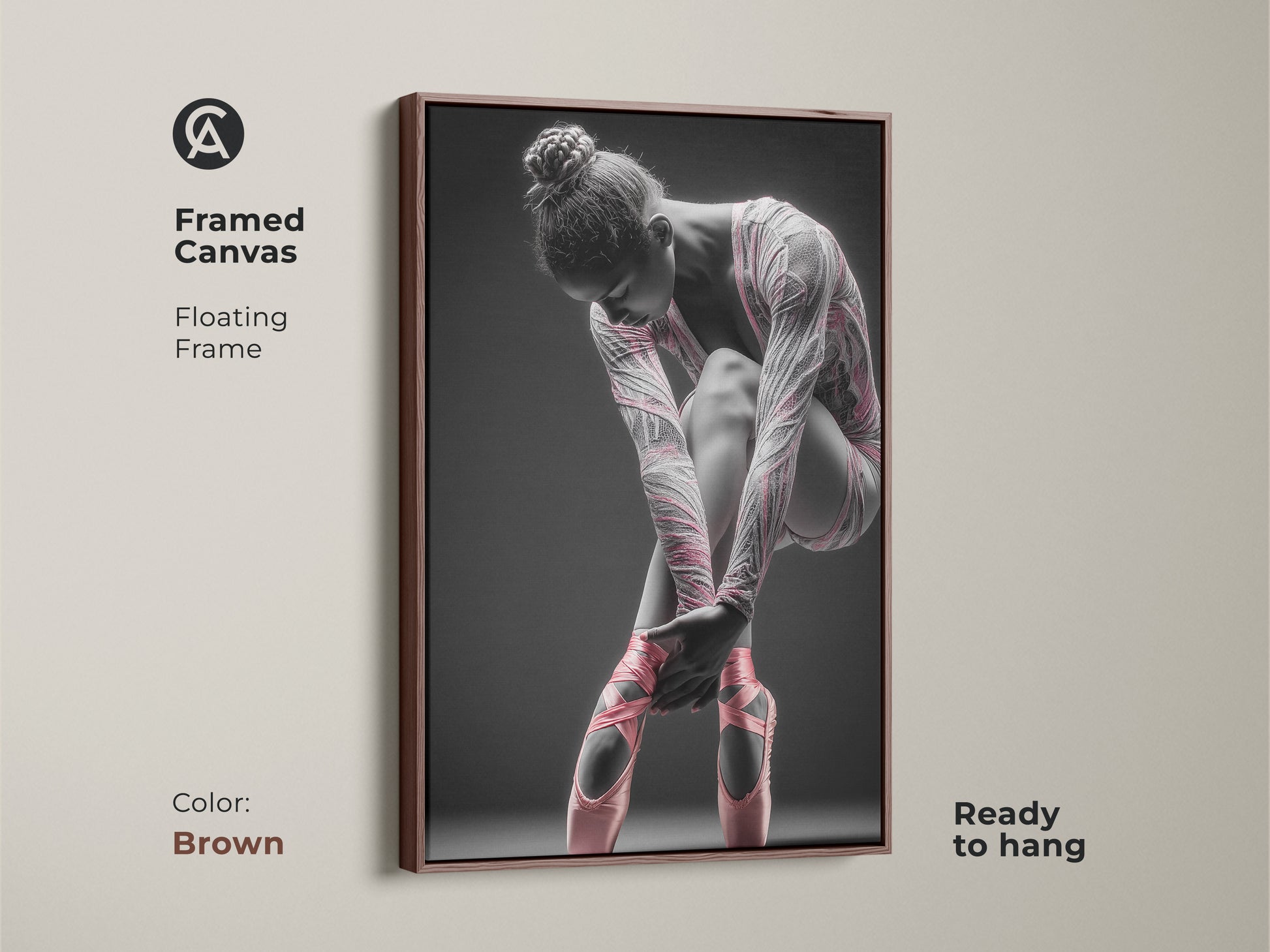 Framed canvas artwork featuring a ballerina. This canvas has a floating frame. The frame color is brown. The art features a ballerina tying her pink ballet shoes. This framed art is ready to hang.