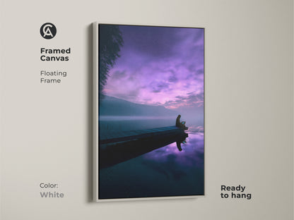 Framed canvas artwork featuring a serene lake scene and violet night sky. It shows a person on a dock under a cosmic sky. This minimalist poster is ready to hang. A unique housewarming gift with deep blue tones.