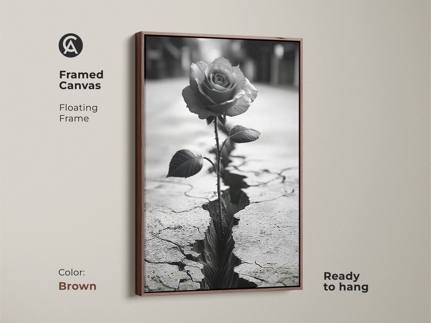 Framed canvas art with a brown floating frame. Showcases a monochrome rose blooming from cracked ground. Symbolizes resilience and nature. The black and white rose art adds a touch of contemporary style. Ready to hang. Perfect as a housewarming gift or symbolic nature decor.