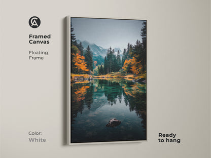 Brighten your living space with this framed canvas artwork. The floating frame in white complements the serene mountain lake scene. The artwork captures a tranquil lake reflecting the surrounding forest and mountains. It's ready to hang and enjoy. Elevate your home decor