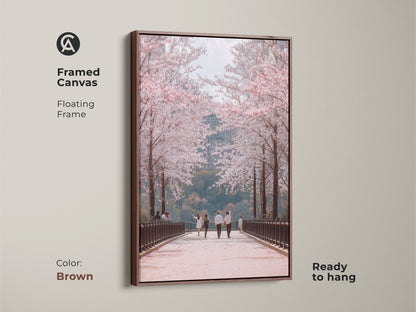 Enhance your space with this framed canvas art. A brown floating frame highlights a couple walking under cherry blossoms. This contemporary nature art adds elegance to any room. Ready to hang this romantic spring scene brings seasonal beauty to your home.