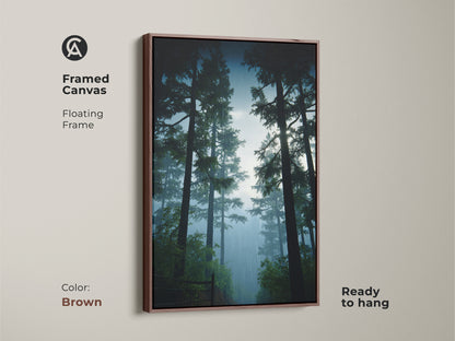 Framed canvas artwork of a serene pine forest. The brown floating frame complements the natural landscape. This deep green and misty blue art is ready to hang in your home.