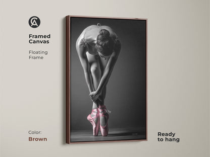 Brown framed canvas of a ballerina. This art piece features a dancer in pink pointe shoes. A floating frame adds sophistication. The canvas is ready to hang and admire in your space.
