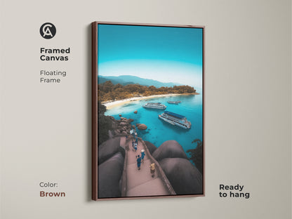 Framed canvas featuring an aerial island beach. Brown floating frame complements the turquoise ocean view art. This coastal landscape wall art is ready to hang. The boat filled bay print captures a tropical island getaway. The blue water seascape adds summer vacation vibes. It's perfect for beach house decor.