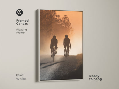 Framed canvas art featuring a cycling couple silhouette. The modern road artwork has a floating white frame and is ready to hang. Perfect modern entryway home decor or a unique gift for cyclists. Captures a sense of journey and shared experience.