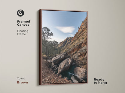 Framed canvas art of a Rocky Mountain landscape with a brown floating frame. This rustic wall decor features sky blue nature photography and gnarled trees. Ready to hang this is a perfect hiker gift. Enhance your space with this scenic mountain view.