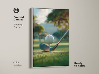 A white framed canvas golf art print ready to hang. The artwork shows a golf ball on a tee ready to be hit. The background is a green golf course with trees and a hill. This framed golf art print is perfect for your home or office.