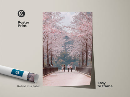 This poster print showcases a couple on a cherry blossom path. It is an elegant travel art piece rolled in a tube for easy framing. The pastel pink and green tones create a soft botanical artwork. Ideal as springtime wall decor for a bedroom or living space.