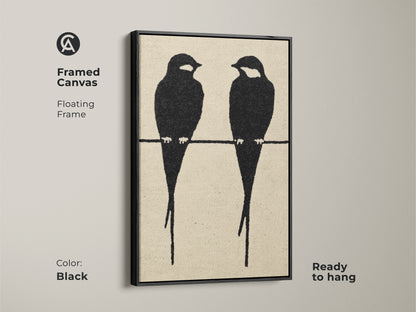 Framed canvas showcasing minimalist black bird artwork. Two bird silhouettes are perched on a wire in this modern abstract piece. The floating frame enhances this black cream art print. The Scandinavian-style art adds a touch of elegance. This art is ready to hang in any modern space.