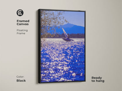 A framed canvas features a sailboat art print on blue water. The black floating frame enhances this coastal artwork. Ready to hang this nautical scene transforms any space. It's perfect wall decor for boaters and sailors.