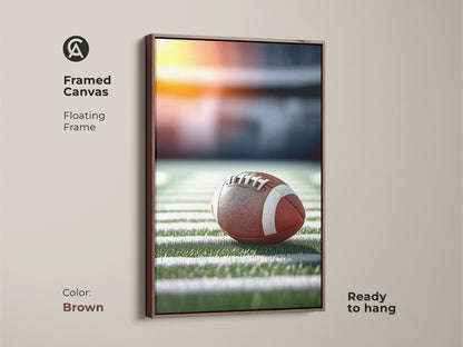 Brown framed canvas featuring a realistic football. It's on a stadium field under bright lights. The floating frame is brown. This sports fan wall decor is ready to hang. Perfect for a man cave or office football art.