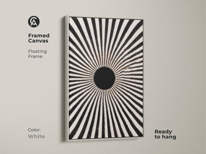A framed canvas featuring a minimalist sunburst print. This floating frame enhances the black and white artwork. It is a mid-century modern geometric art piece. The white frame adds to the monochrome sunburst print. This ready-to-hang radial wall decor is perfect for any home. This abstract line art print fits a minimalist style.