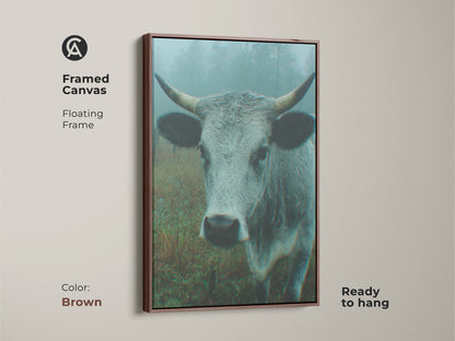 Framed canvas artwork of a cow in a misty field with a brown floating frame. This ready-to-hang piece adds warmth to your home decor. It is a timeless and elegant art choice.