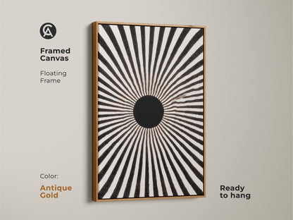 Framed canvas featuring a black and white geometric art. Its antique gold floating frame enhances the artwork. This mid-century modern piece is a radial wall decor. The sunburst motif canvas is ready to hang. The minimalist home decor will be a great housewarming gift. It is impactful wall art for entry halls.