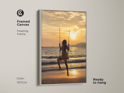 Framed canvas with a floating white frame showing a woman on a swing at sunset. The golden yellow ocean waves evoke a sense of summer vacation. This ready-to-hang artwork is perfect for boho coastal bedroom decor. A serene beach scene print brings a touch of travel to any room.