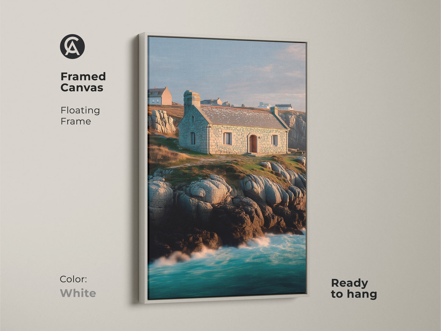 Framed canvas of a coastal stone cottage landscape. Floating frame in white finish highlights the art. Ocean waves and rocky coastline artwork create a peaceful atmosphere. Blue green teal colors add a touch of coastal charm. Ready to hang.