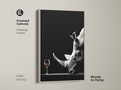 A framed canvas art print features a surreal rhino with a wine glass. The monochrome wildlife art comes with a clean white frame. Ready to hang this contemporary artwork is ideal for modern spaces. This unique animal artwork makes a sophisticated and unusual piece for home decor.