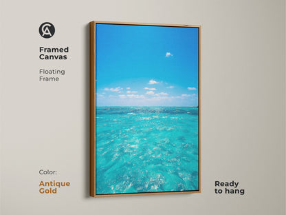 Framed canvas art of turquoise ocean waves with an antique gold floating frame. Realistic seascape art print for a coastal home. The blue ocean water artwork brings summer vacation vibes to your wall.
