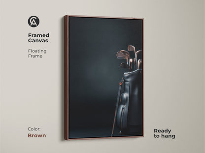 Framed canvas art print featuring golf clubs in a black bag. The floating frame is brown. The artwork is ready to hang. This stylish sports themed piece adds sophistication to any room. Purchase this framed art today.