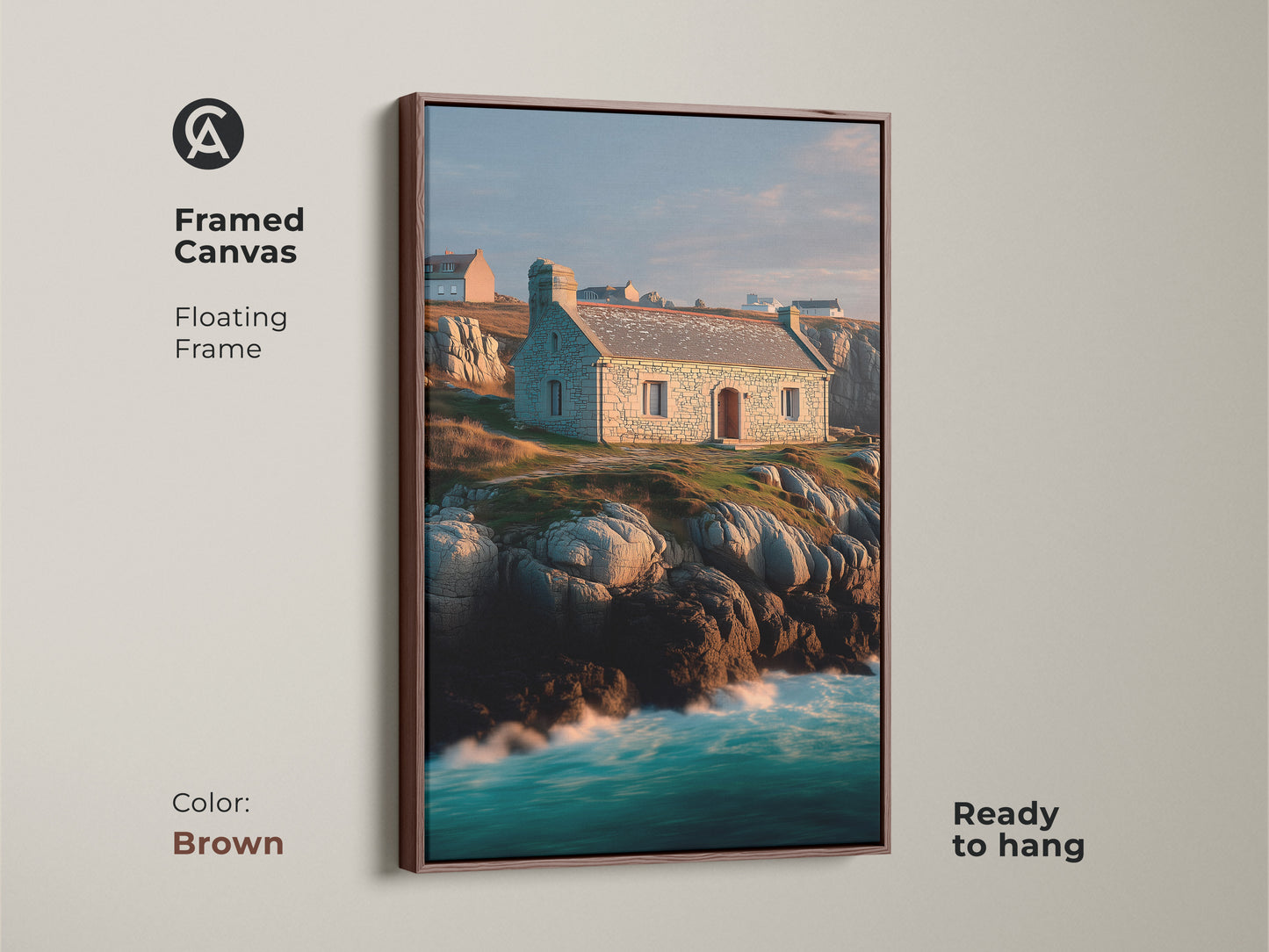 Framed canvas of coastal stone cottage art. Floating frame in brown finish complements the blue ocean waves. Realistic seascape featuring a stone house on a rocky coastline. Perfect housewarming gift for art lovers. Ready to hang.