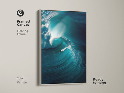 This framed canvas artwork shows a surfer riding a massive wave. The white floating frame gives it a clean modern look. This ocean art print is ready to hang. This artwork will bring the beauty of the ocean to your living space.