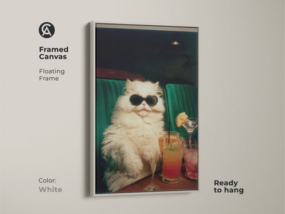 White framed canvas art print of a fluffy white cat wearing sunglasses. The cat sits in a green booth with cocktails. This framed artwork offers a clean and modern aesthetic. Ready to hang and enjoy in any room.