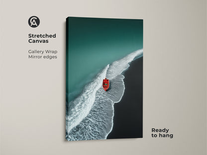 Stretched canvas print of an aerial beach. Teal waves gently meet the dark sand. A red boat is featured. Gallery wrapped with mirrored edges. Ready to hang coastal wall decor.
