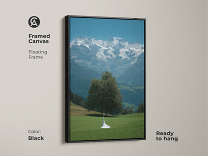 Framed canvas of cinematic mountain artwork with a black floating frame. This fine art nature print displays a bride figure. Nature artwork ideal as a wedding gift canvas. Blue green wall decor for contemporary homes. This bridal gown and mountains art piece is ready to hang. Inspired by travel and romantic landscapes.