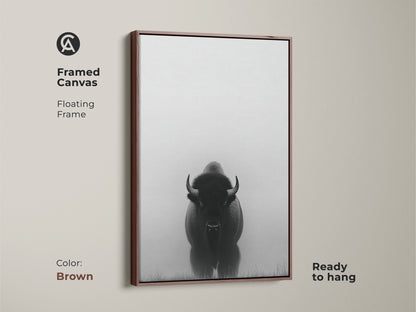 A framed canvas features minimalist bison art in brown. This black and white prairie canvas is ready to hang. The wildlife animal landscape print adds a rustic farmhouse touch to any room.
