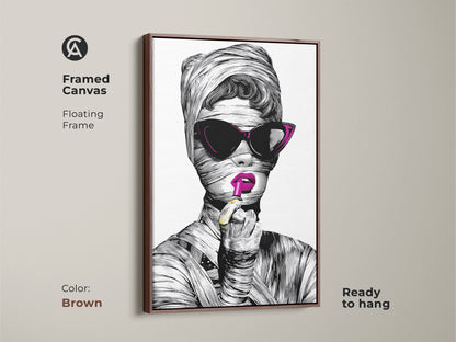 A framed canvas featuring a surreal woman with magenta lipstick. The brown floating frame complements the pop art woman portrait. This unique wall art gift is perfect for fashionista home decor. It's a modern eclectic decor piece ready to hang.