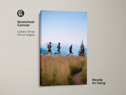 A stretched canvas print shows trail runners ascending a mountain path. This gallery-wrapped artwork has mirror edges and is ready to hang. The earthy brown and sky blue tones create a modern outdoor feel. Ideal for adding adventure-themed decor to any space. Perfect for hiker gift ideas.